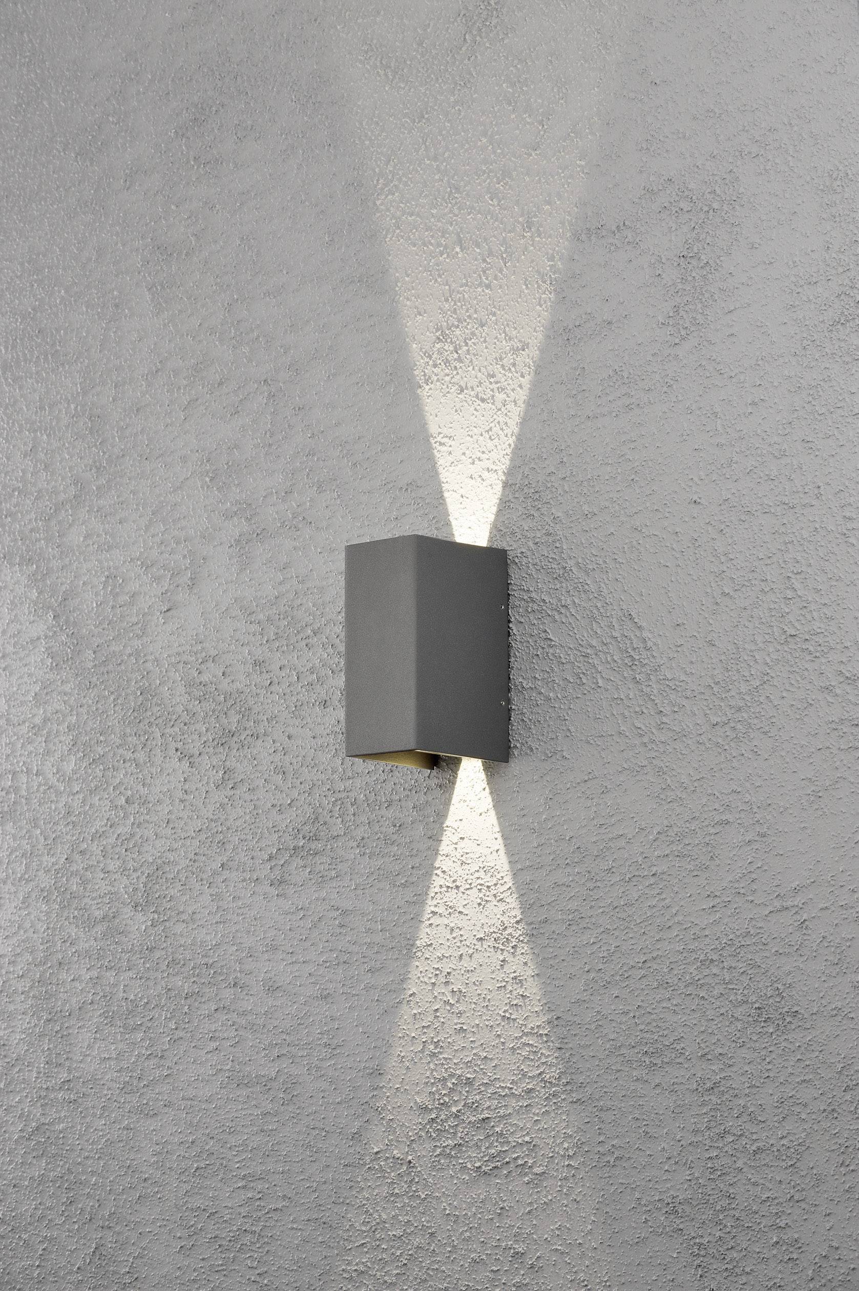 Moderne Wandlampe an einer strukturierten, grauen Wand, strahlt Licht nach oben und unten. Minimalistisches Design für stilvolle Beleuchtung.