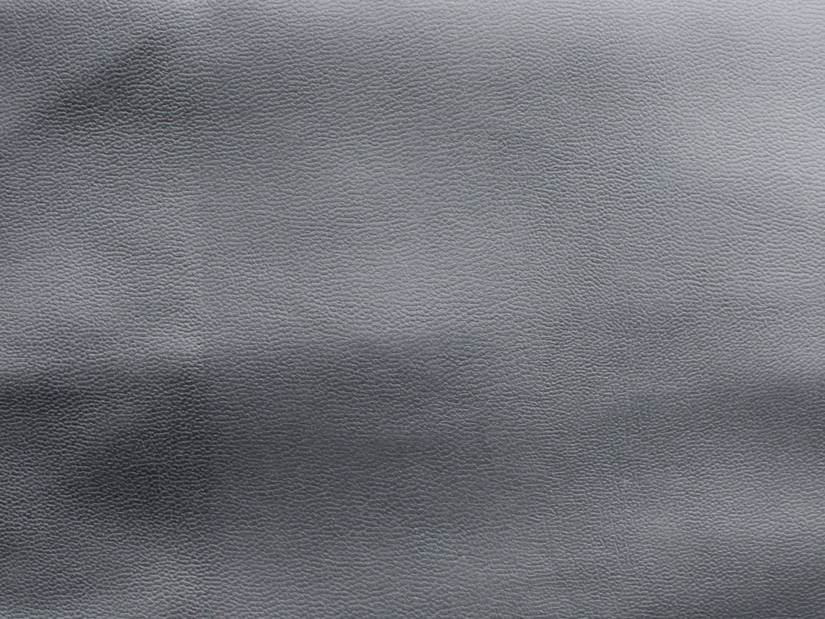 Eine nahe Ansicht von grauem Leder mit einer feinen, gleichmäßigen Narbenstruktur.