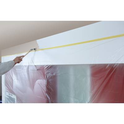 Eine Person streicht mit einem Pinsel eine Wand weiß. Ein Teil der Wand ist mit Plastikfolie abgedeckt, um sie vor Farbe zu schützen.