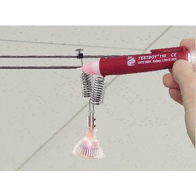 Eine Hand hält einen Spannungsprüfer an einen Drahtseil-Track mit einer montierten Lampe, um die Spannung zu überprüfen.