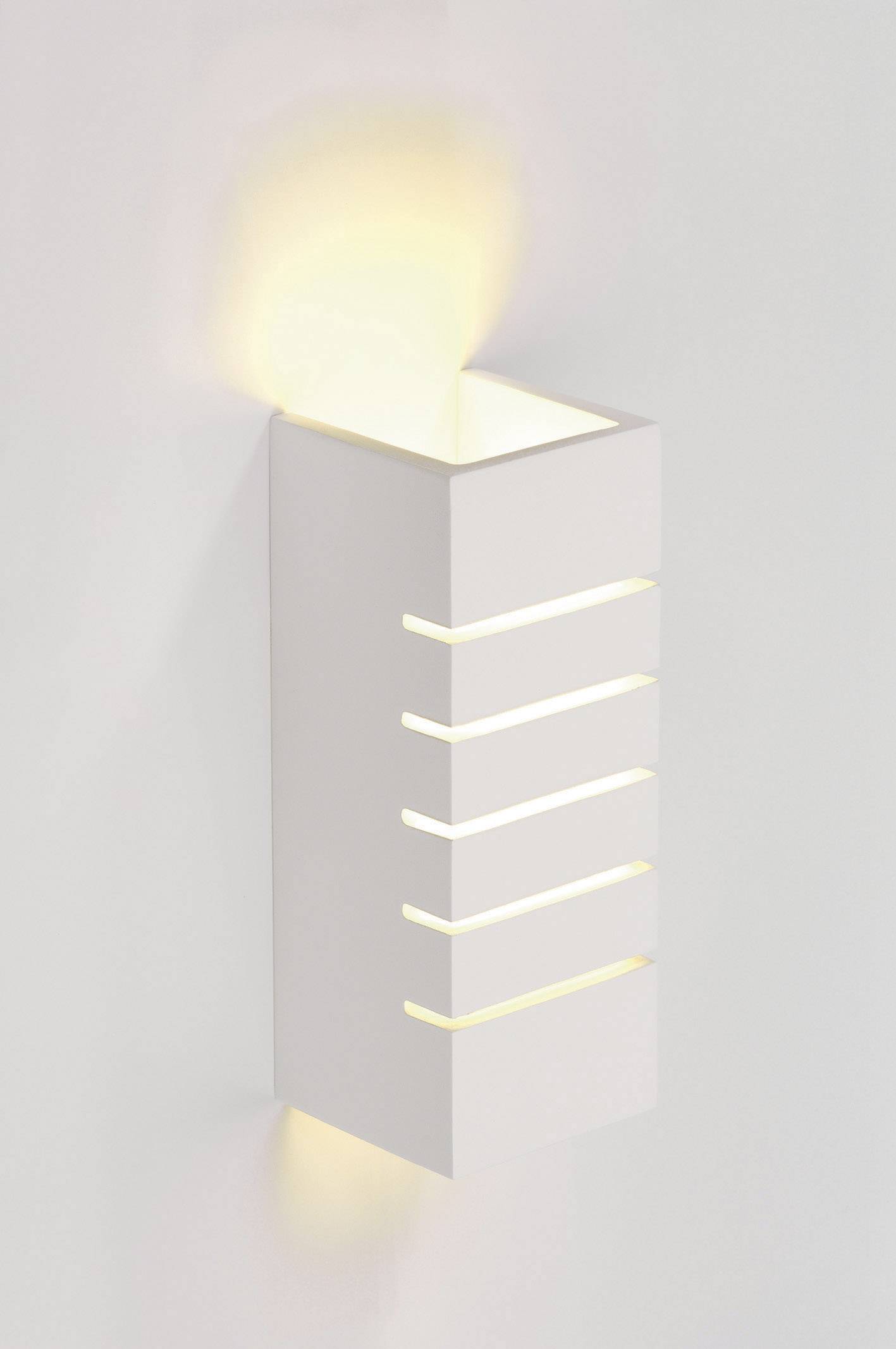 Weiße Wandleuchte mit schmalen, horizontalen Schlitzen, durch die Licht strömt. Obere und untere Öffnung erzeugt sanften Lichteffekt.