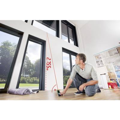 Ein Mann misst mit einem Laser-Entfernungsmesser die Höhe eines großen Fensters im Raum. Die Höhe beträgt 2,75 m.