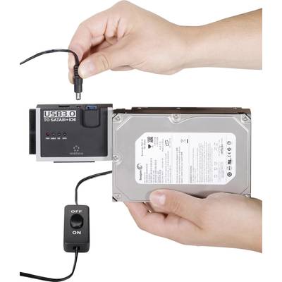 'Zwei Hände verbinden eine externe USB 3.0 zu SATA/IDE Adapterkarte mit einer Festplatte. Der Adapter hat einen Ein-/Ausschalter.'