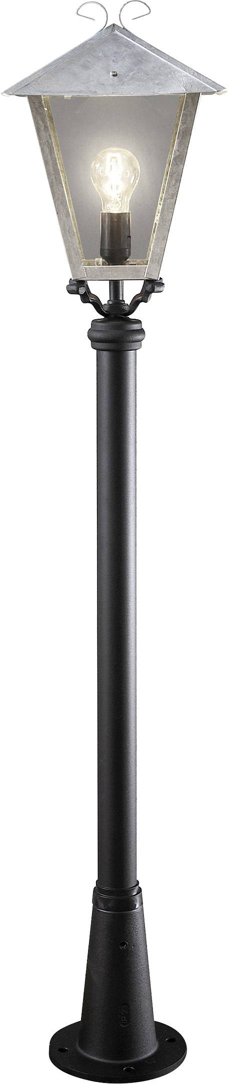 Eine schwarze Laterne aus Metall mit transparentem Lampenschirm. Eine Glühbirne ist im Inneren sichtbar und leuchtet.