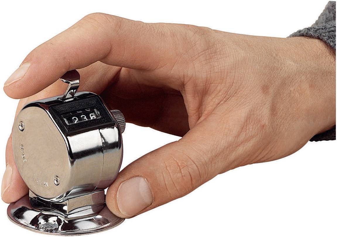 Hand hält einen mechanischen Zählgerät mit Anzeige '236'. Gerät aus Metall, in der Handfläche gehalten, typisch für manuelle Zählung.