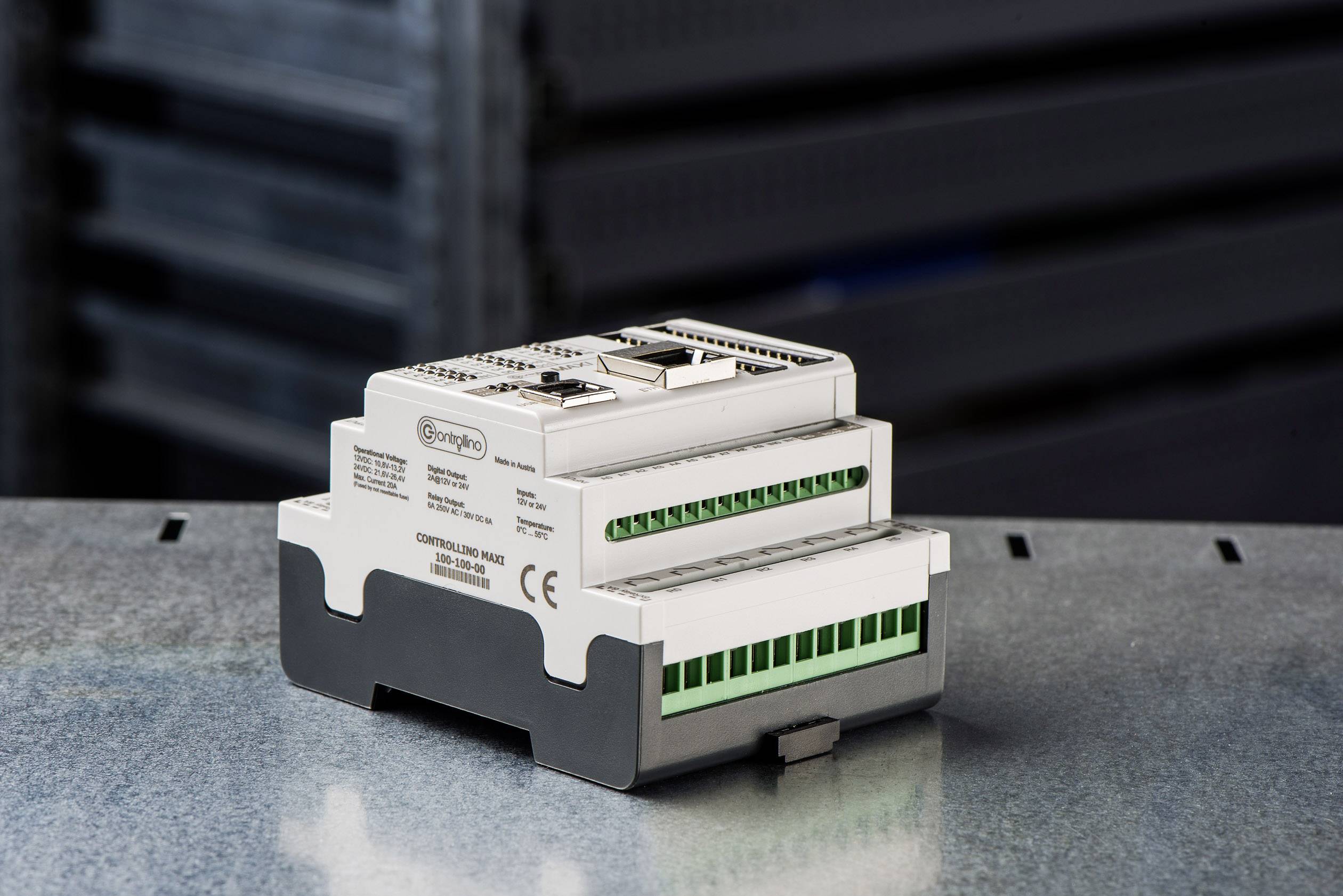 Industrie-PC mit mehreren grünen Anschlüssen und CE-Kennzeichnung, platziert auf metallischer Oberfläche in einer Lagerumgebung.