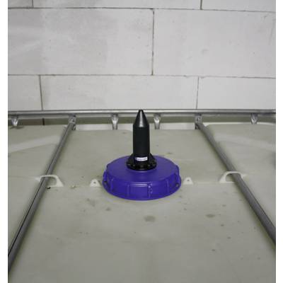 Blauer Kunststoffdeckel mit schwarzem Zubehörteil auf einem großen Kunststoffbehälter vor einer weißen Mauer.