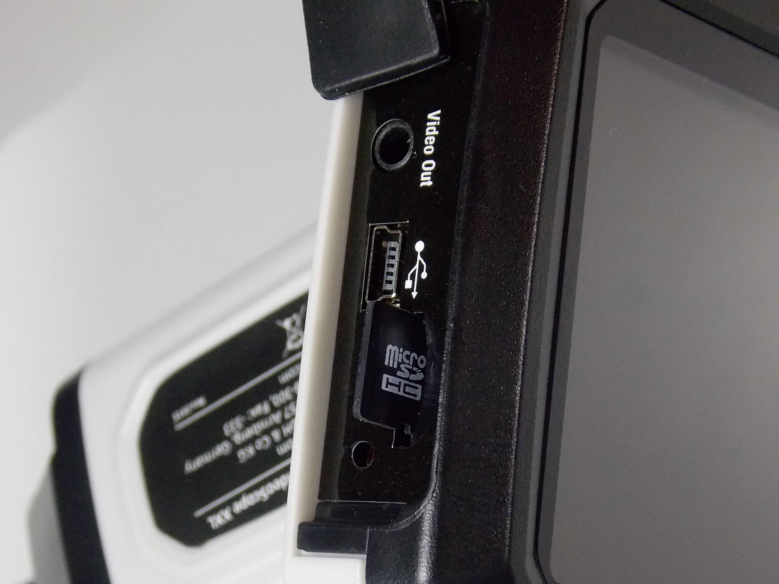 Nahaufnahme eines elektronischen Geräts mit einem Steckplatz für eine MicroSD-Karte, einem USB-Anschluss und einer Videoausgabe.
