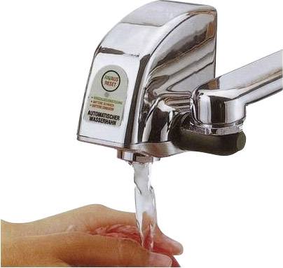 Eine Hand wird unter einem automatischen Wasserhahn gewaschen. Der Wasserhahn aktiviert sich berührungslos und spendet Wasser.