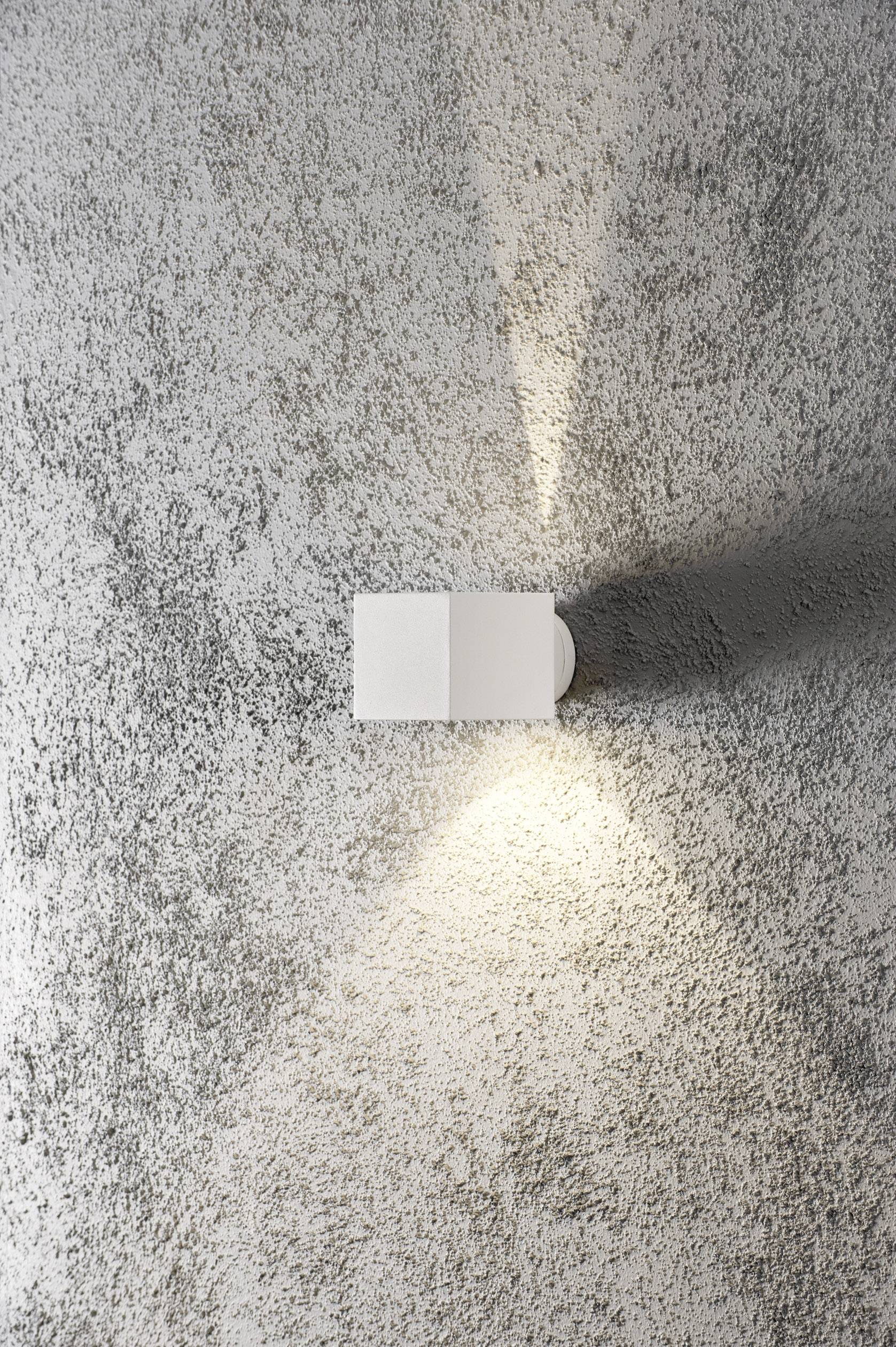 Weiße Wandlampe leuchtet nach oben und unten auf strukturiertem grauem Hintergrund.