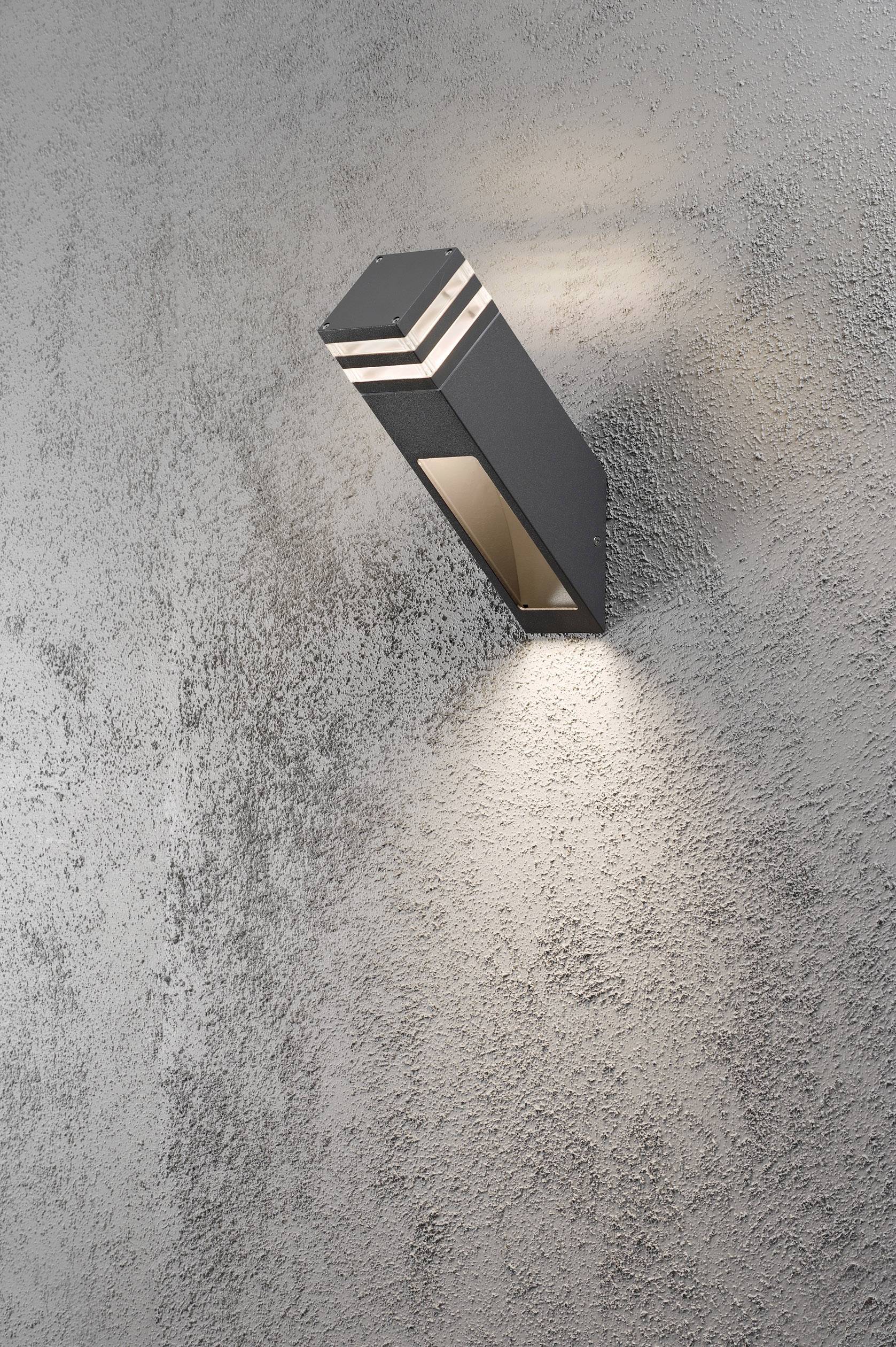 Außenlampe an grauer Wand, strahlt warmes Licht nach oben und unten, modern und schlichtes Design, geeignet für Außenbereiche.