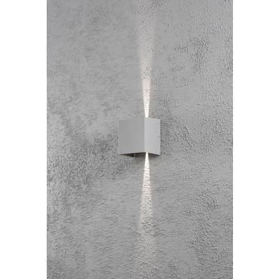 Eine graue, quadratische Wandleuchte auf einer rauen, grauen Wand, wirft Licht nach oben und unten in schmalen Kegeln.
