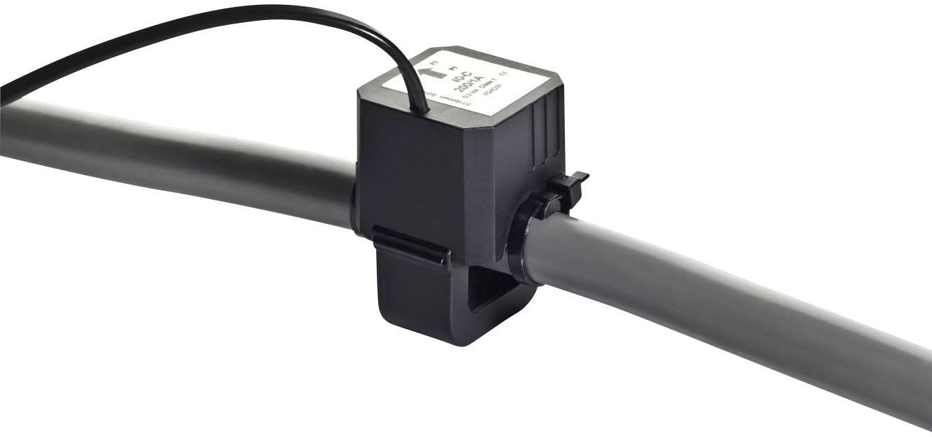 Ein Wasserrohr mit einem installierten Durchflusssensor, umgeben von einem schwarzen Gehäuse aus Kunststoff, misst den Flüssigkeitsfluss.