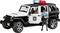Spielzeugmodel eines Polizeijeep mit Miniatur-Polizist davor. Fahrzeug hat Polizei-Schriftzug und rote, blaue Lichter.