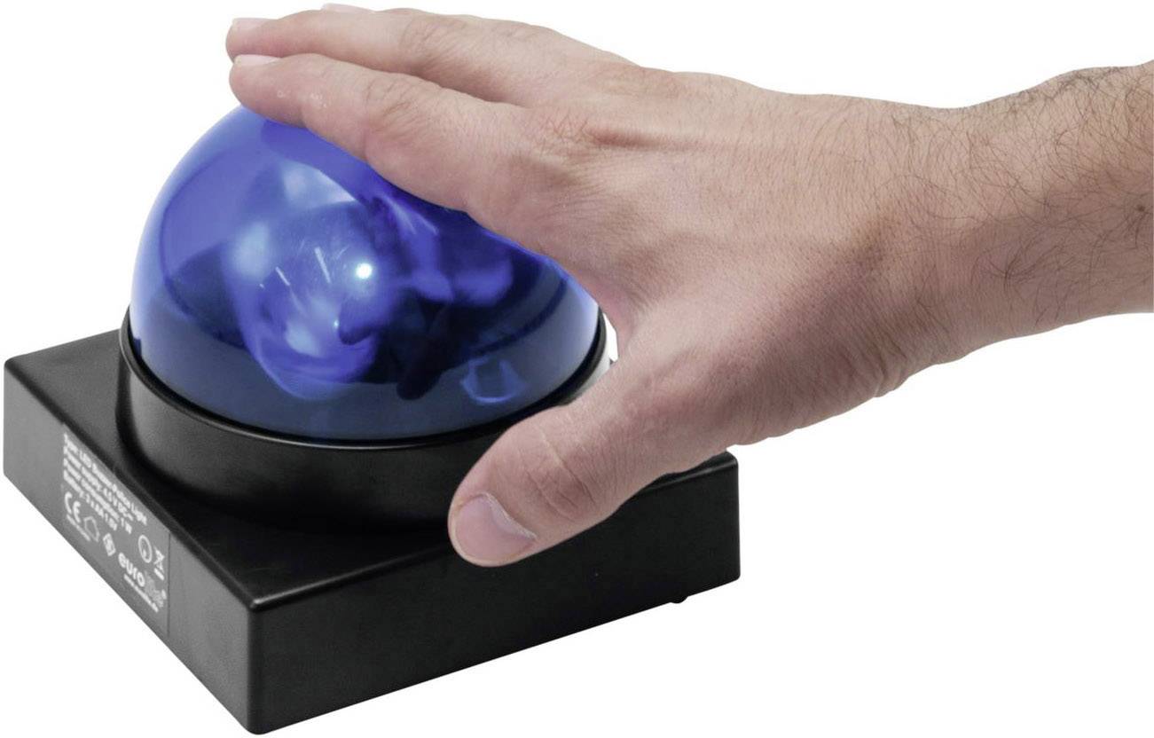 Eine Hand drückt auf eine blaue Leuchtkugel auf einem schwarzen Sockel.