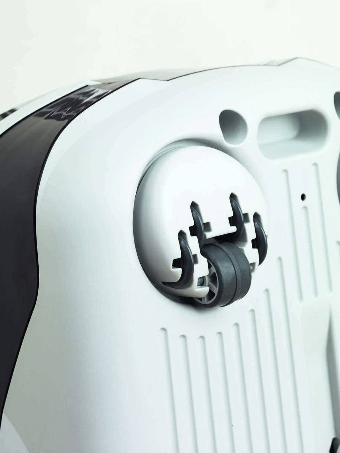 Ein weißes Gerät mit einem Rad und Einsteckhalterungen an der Unterseite, möglicherweise Teil eines Staubsaugers oder Reinigungsgeräts.