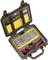 Ein digitales Multimeter in einem schwarzen Hartschalenkoffer mit Schaumstoffeinlage. Das Multimeter ist gelb. Oben liegt eine Anleitung.