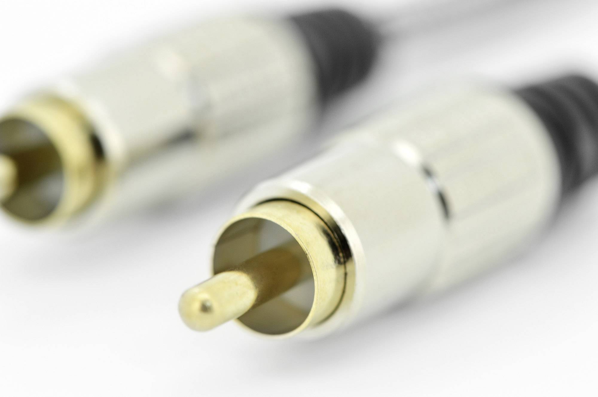 Zwei goldene RCA-Stecker in Nahaufnahme, die für Audio- und Videoverbindungen verwendet werden.