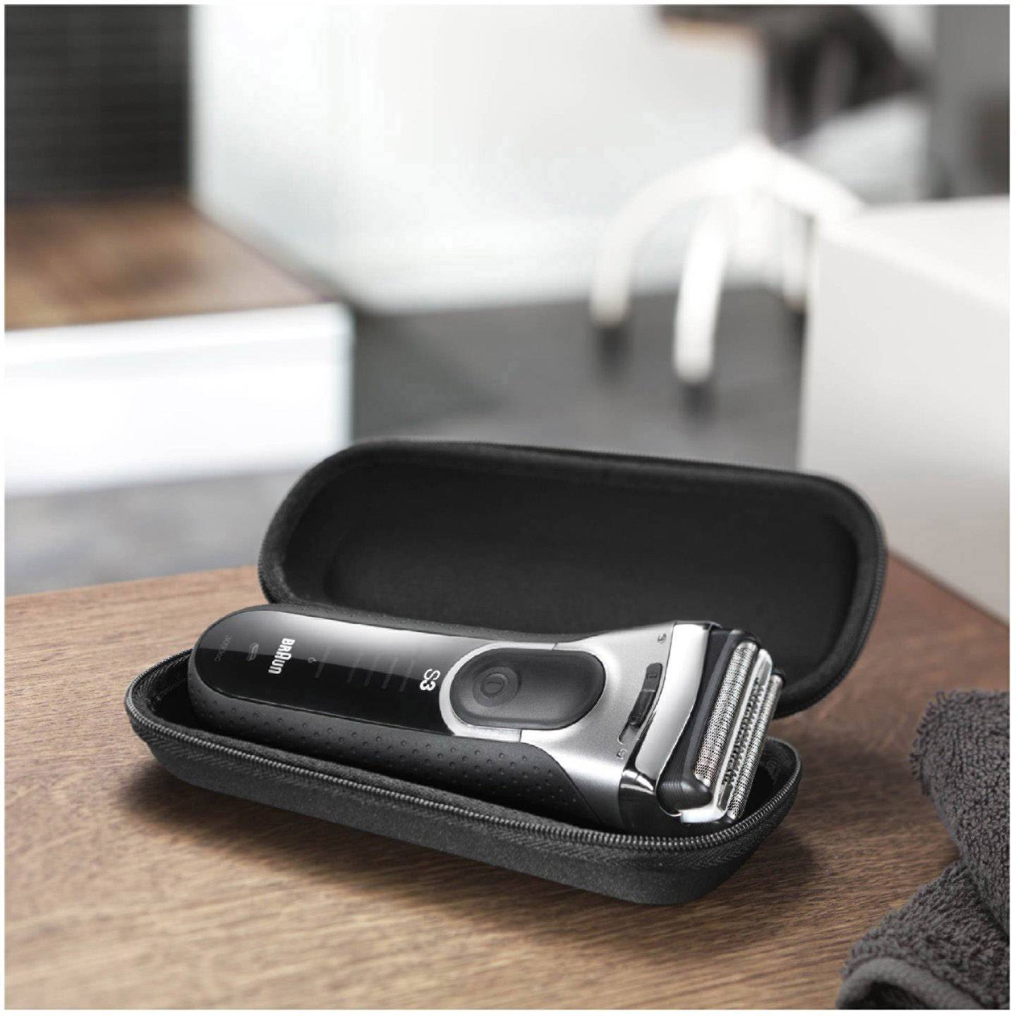 Elektrorasierer in geöffneter Tasche auf einem Tisch, bereit zur Verwendung; modernes Design mit mehreren Klingen.