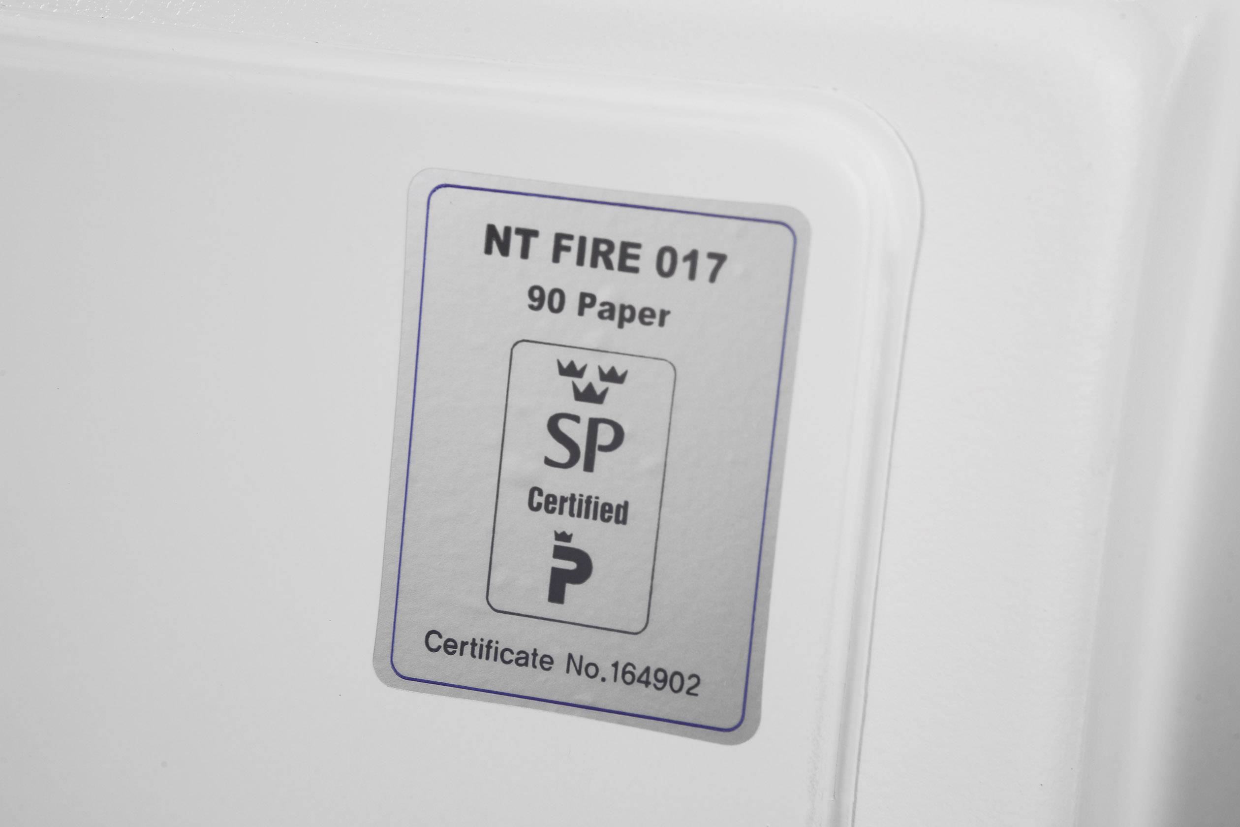 Ein Zertifikat setikett mit der Aufschrift 'NT FIRE 017, 90 Paper, SP Certified' und einer Zertifikatsnummer auf einem weißen Hintergrund.