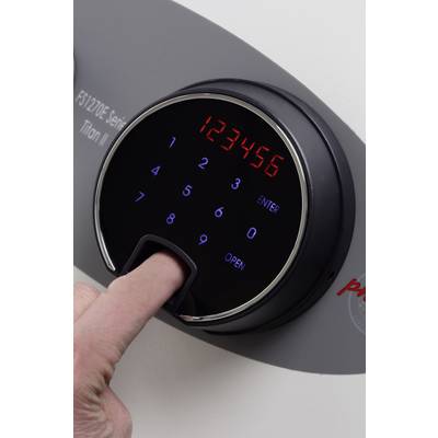 Ein Finger betätigt ein elektronisches Zahlenschloss mit digitalem Display und Fingerabdruckscanner an einem Safe.
