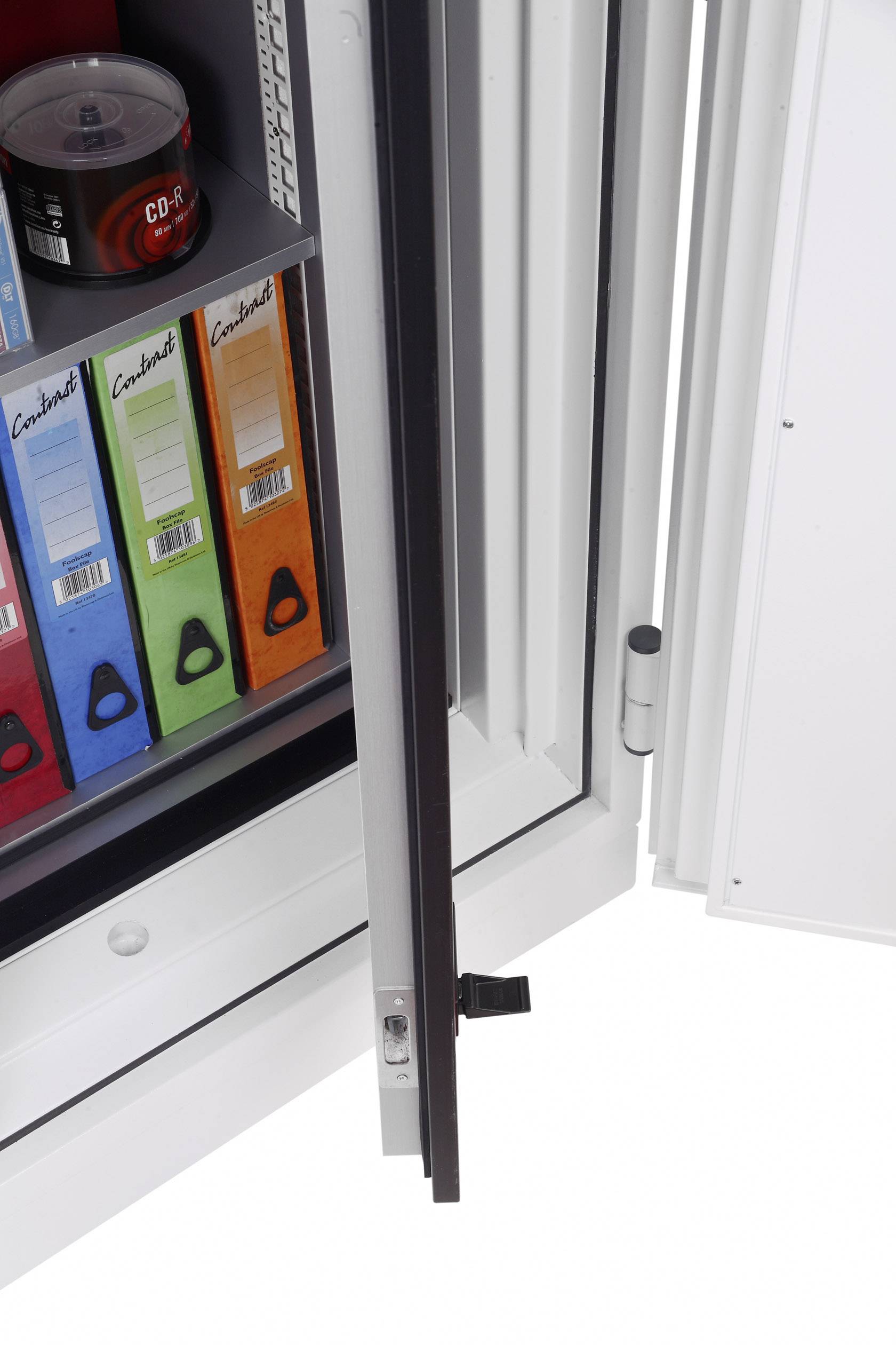 Ein geöffneter Schrank mit Aktenordnern in verschiedenen Farben und einer roten Dose auf der oberen Ablage.