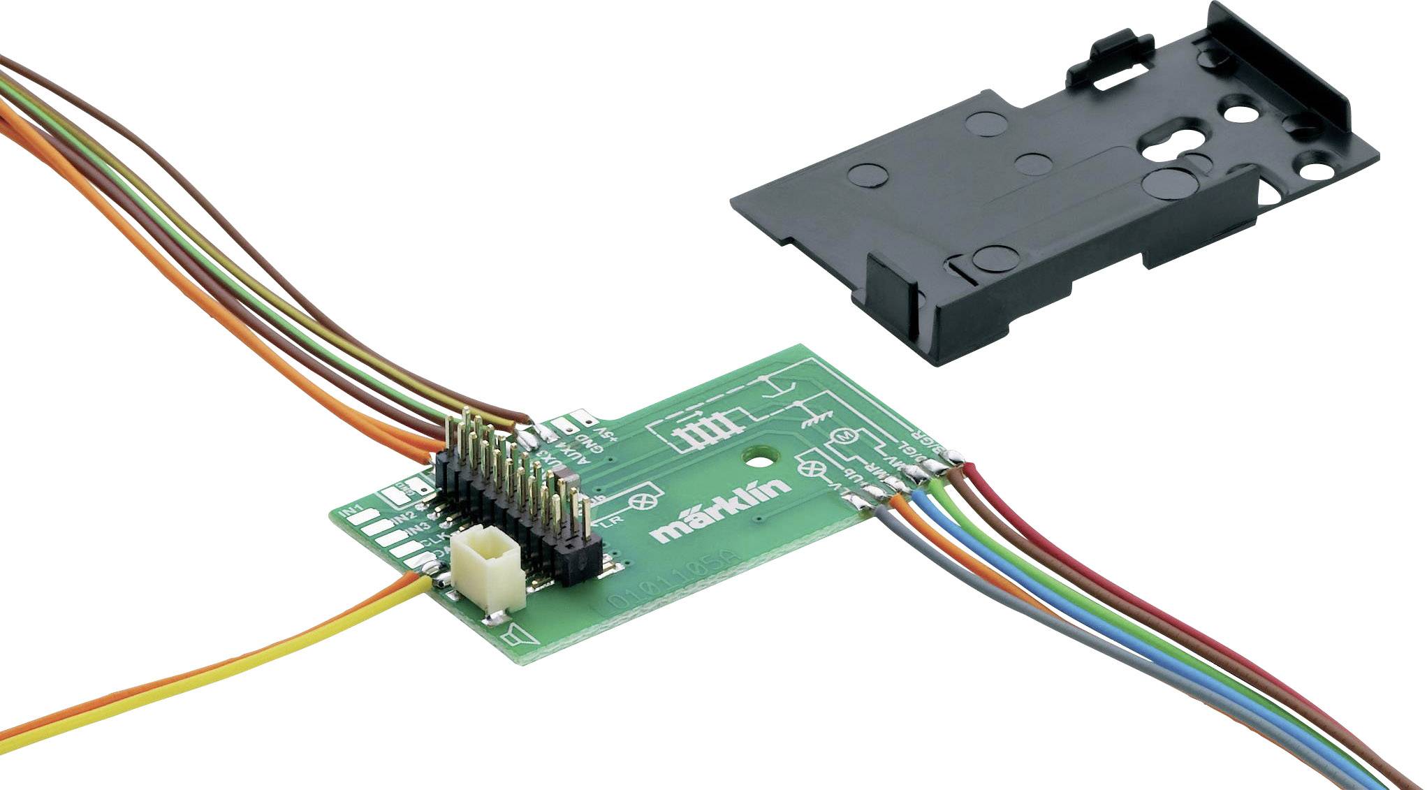 Eine grüne elektronische Schaltplatte mit sieben bunten Kabeln, die daran angeschlossen sind, daneben liegt eine schwarze Abdeckung.