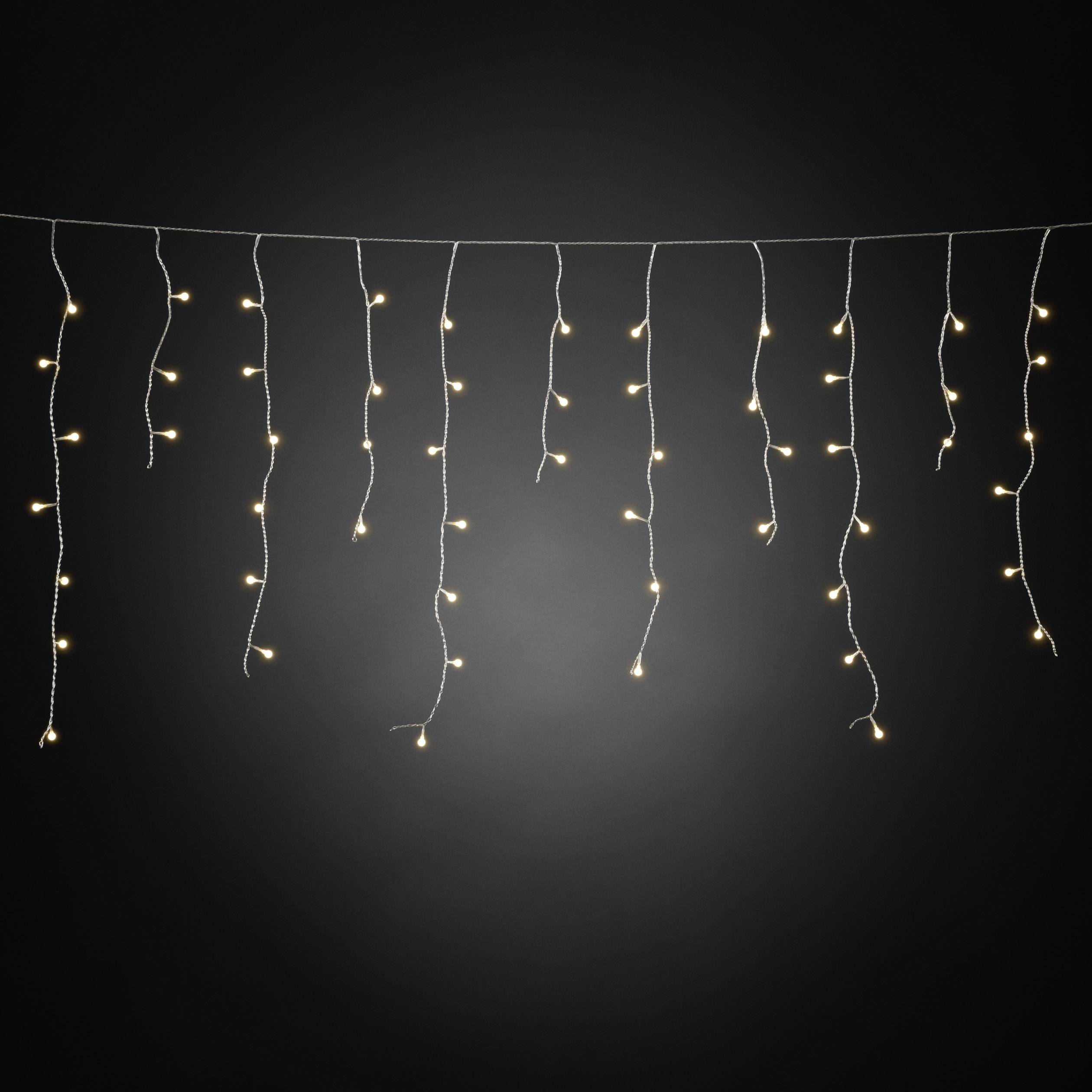 Eine Reihe heller, hängender Lichter vor einem dunklen Hintergrund, die eine warme und festliche Atmosphäre vermitteln.