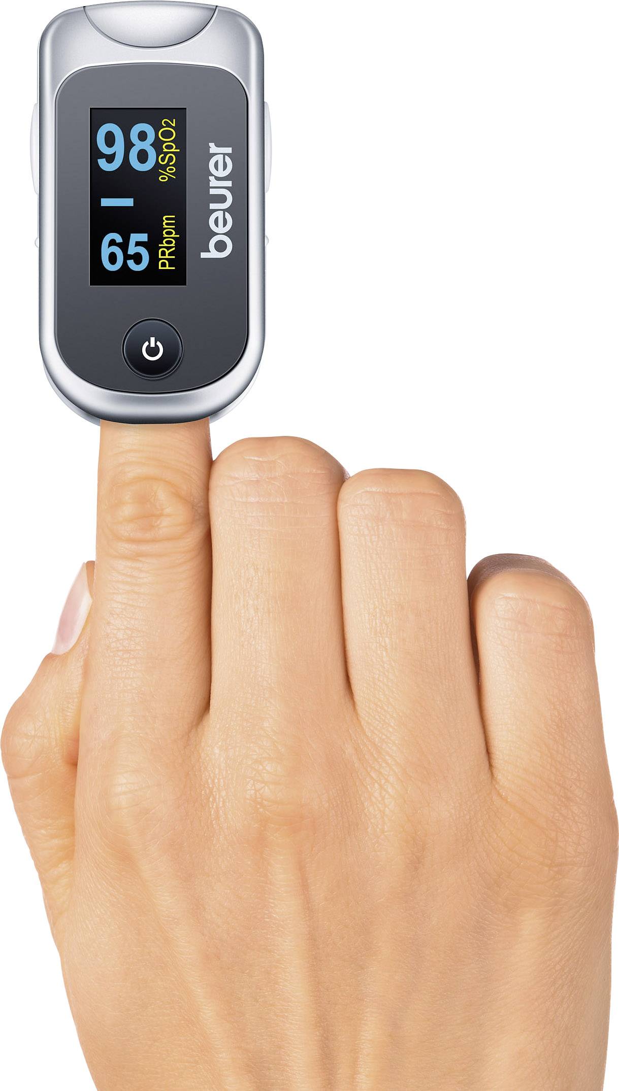 Eine Hand hält ein Pulsoximeter am Finger. Das Display zeigt 'SpO2 98%' und '65 bpm'. Das Gerät misst Sauerstoffsättigung und Puls.