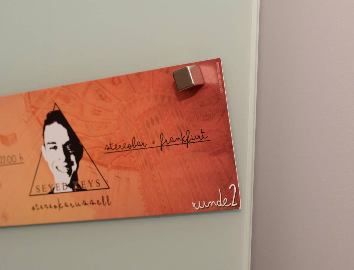 Roter Zettel mit Logo und Unterschrift 'steveban frankfurt', befestigt mit Magnet.