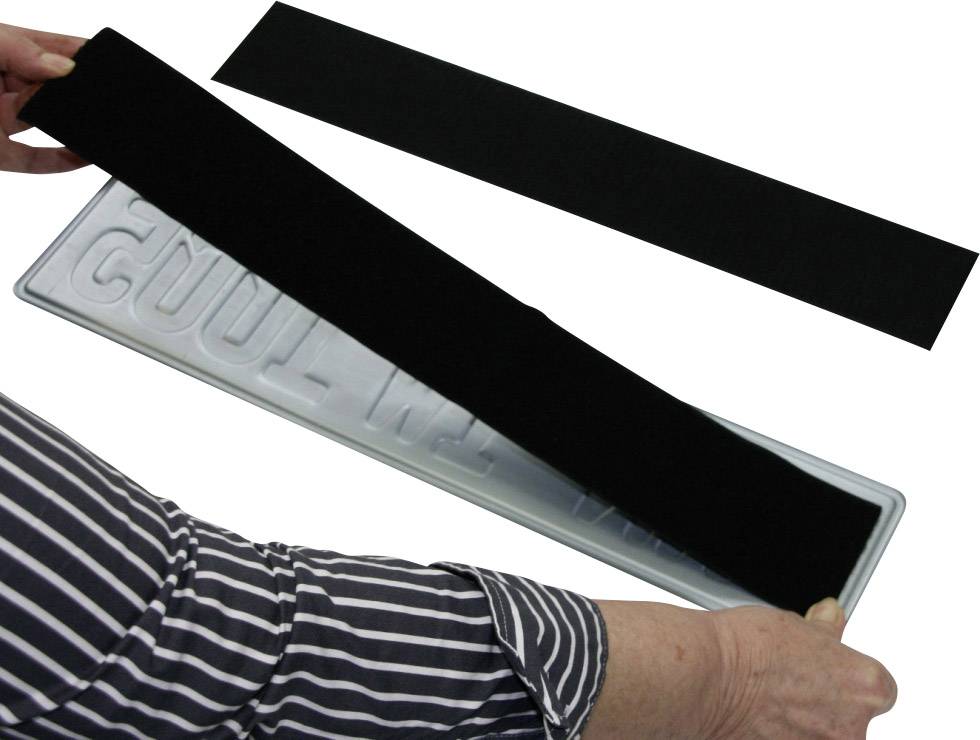 Person befestigt ein schwarzes Klettband auf einem Nummernschildhalter.