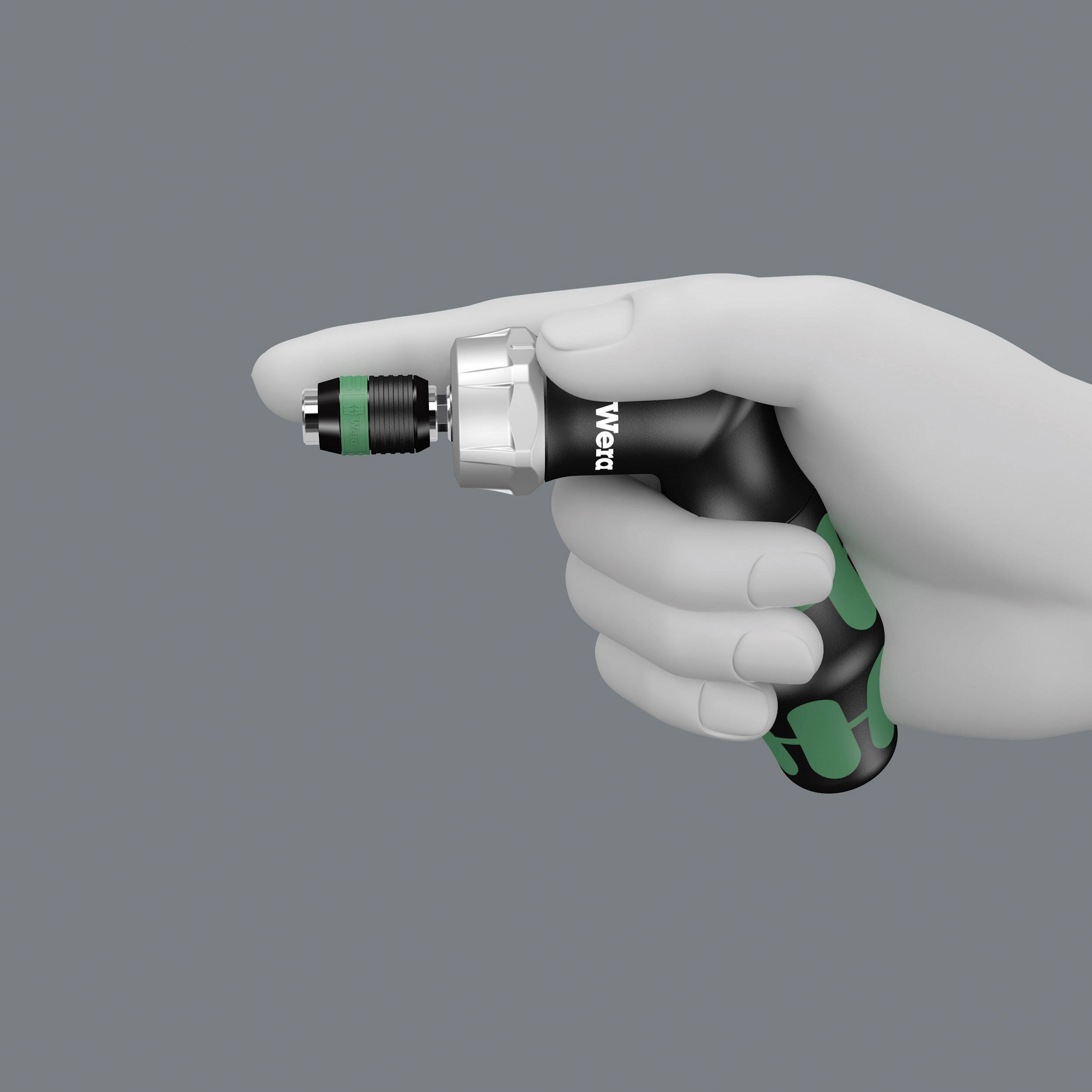 Eine Hand hält ein schwarzes Elektrowerkzeug mit grünem Griff, das vorn eine Metallspitze hat.