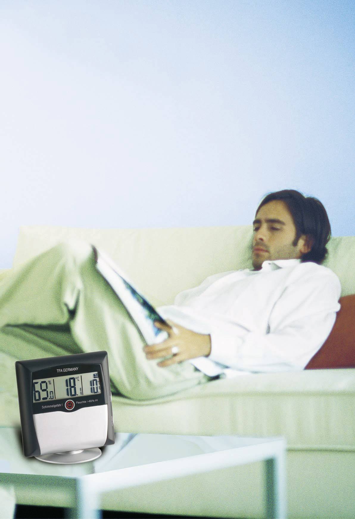 Ein Mann liegt entspannt auf einem Sofa und liest ein Magazin. Im Vordergrund zeigt ein digitales Thermometer die Raumtemperatur an.