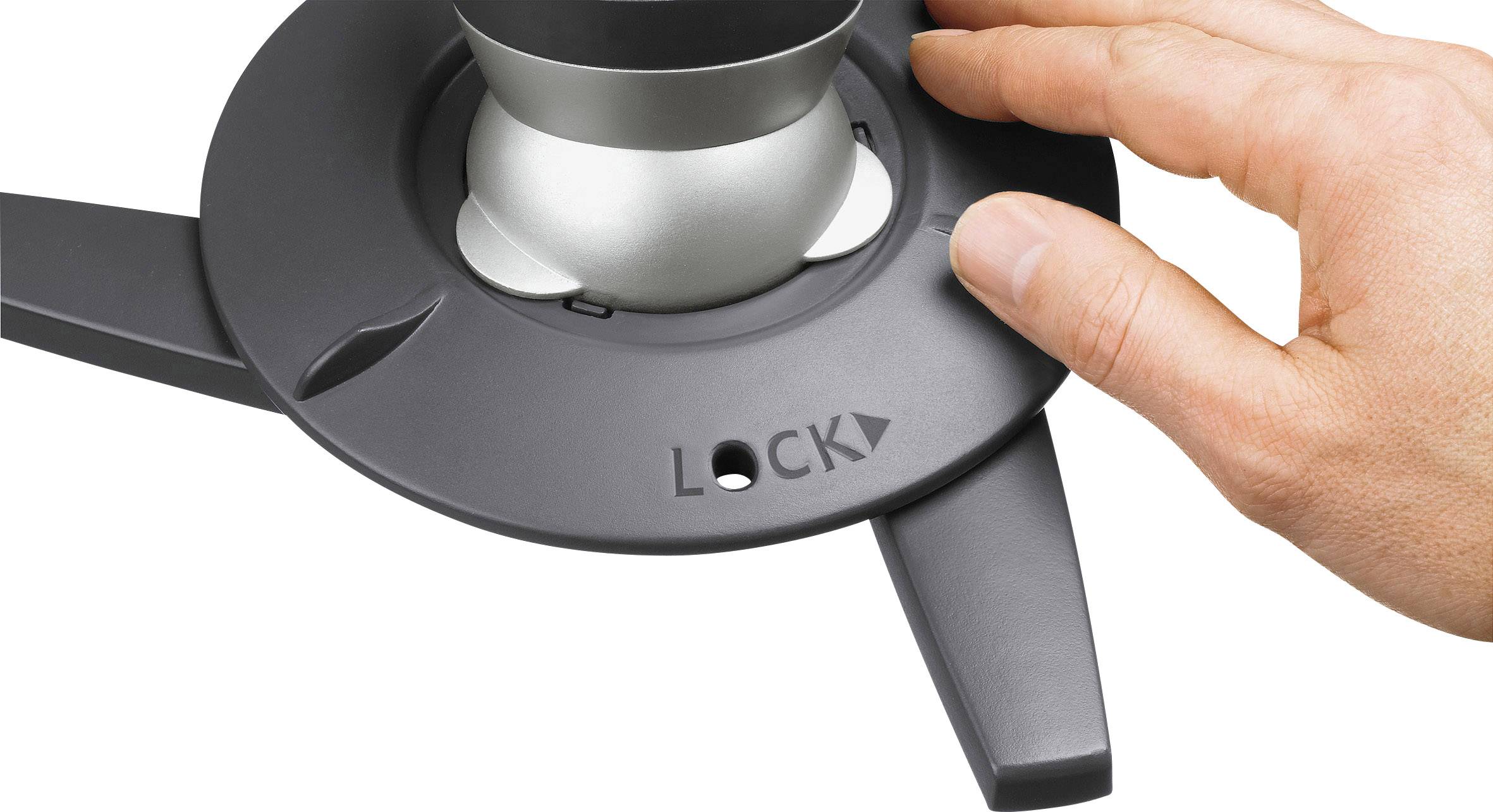 Eine Hand dreht einen silbernen Knopf auf einem schwarzen Drehrad mit "LOCK"-Aufschrift, um das Gerät zu sichern.