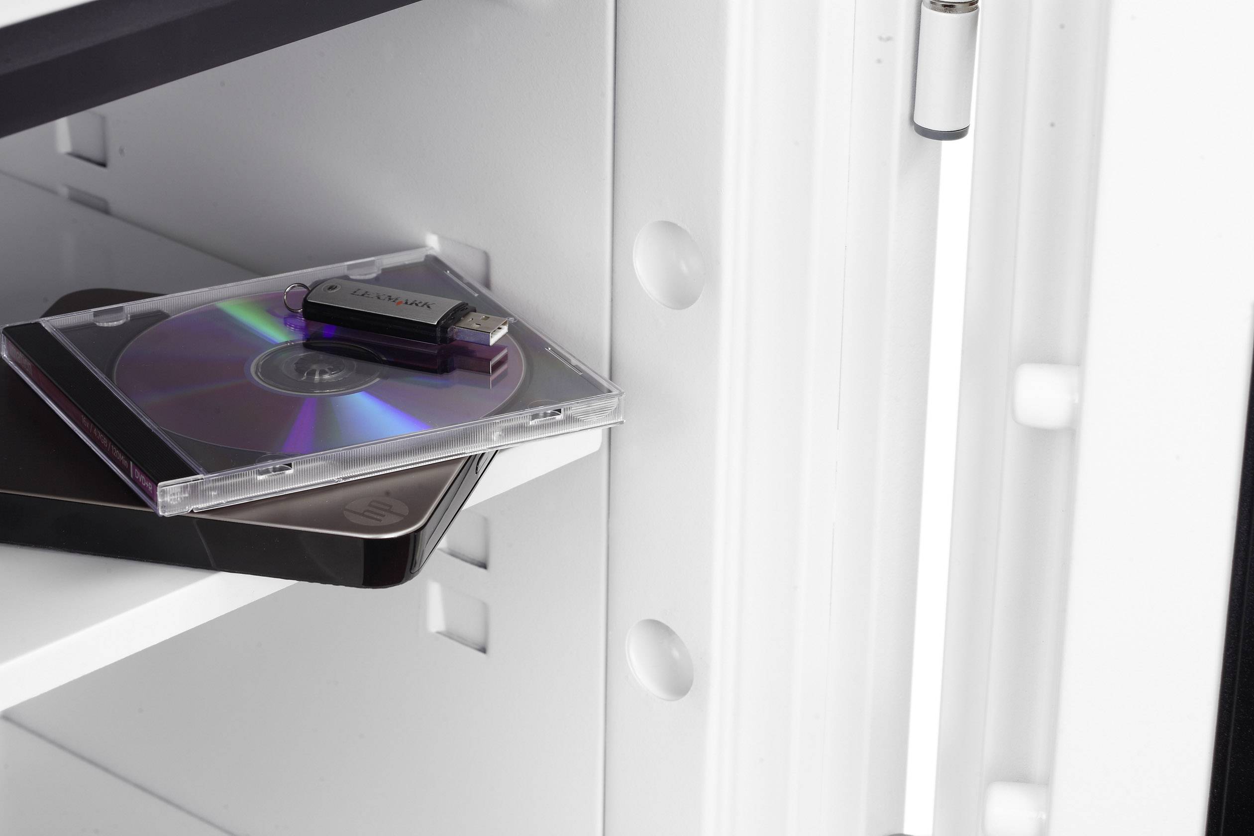 Ein geöffnetes Fach enthält eine CD in Hülle und einen USB-Stick, wahrscheinlich zur Speicherung oder Sicherung von Daten.