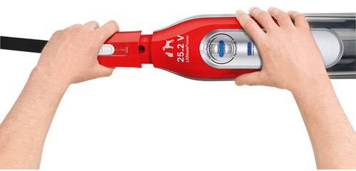 Zwei Hände halten einen rot-schwarzen Staubsauger mit Aufschrift '25.2 V'. Der Fokus liegt auf der Handhabung des Geräts.