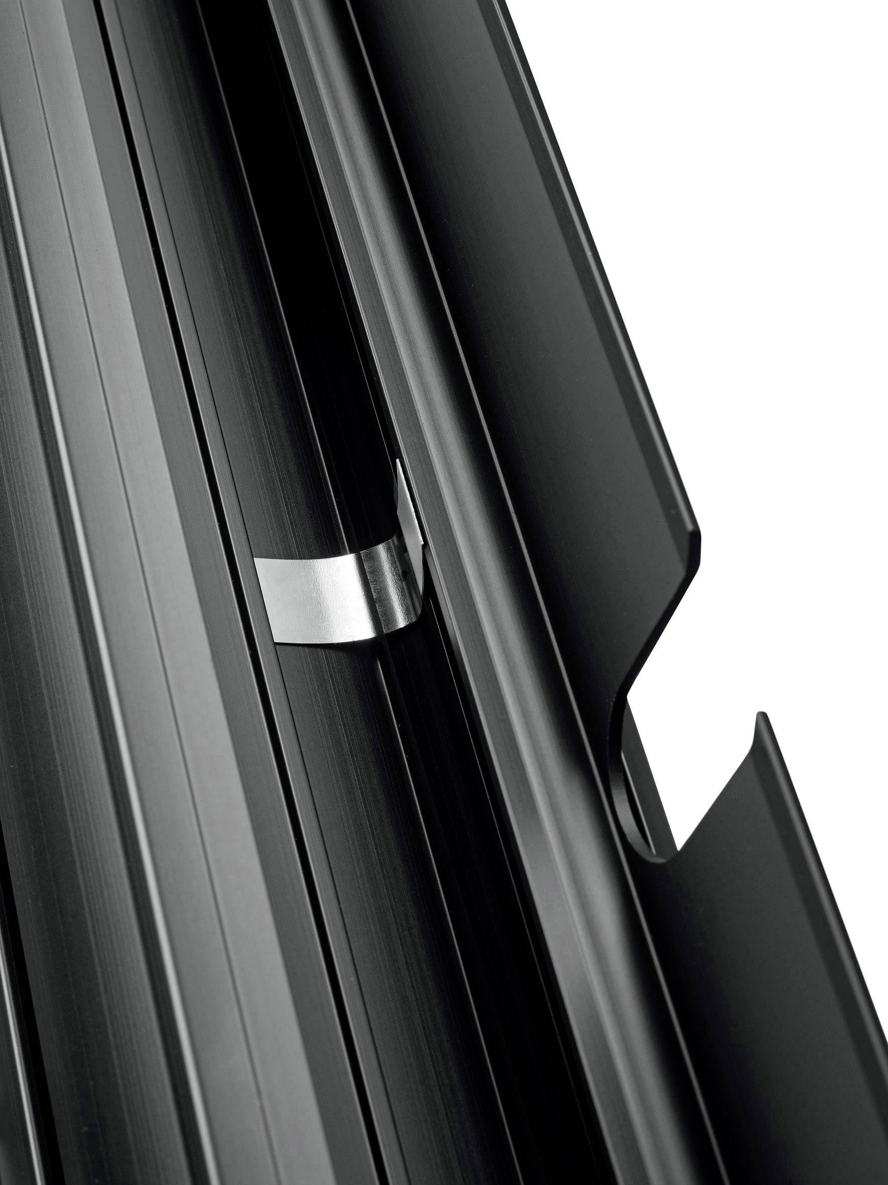 Nahaufnahme eines schwarzen Metallprofils mit Nuten und einer silbernen Klammer in einer Nut, geeignet für Konstruktionssysteme.