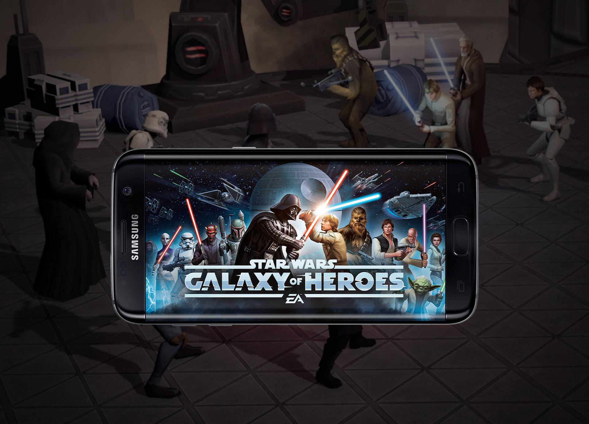 Ein Smartphone mit dem Spiel 'Star Wars Galaxy of Heroes' wird gezeigt. Im Hintergrund sind Figuren in einer Kampfszene zu sehen.