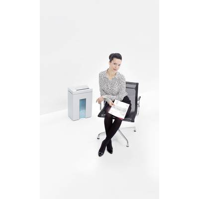 Eine Frau sitzt auf einem Bürostuhl neben einem Aktenvernichter und hält Papiere in der Hand. Der Hintergrund ist schlicht weiß.