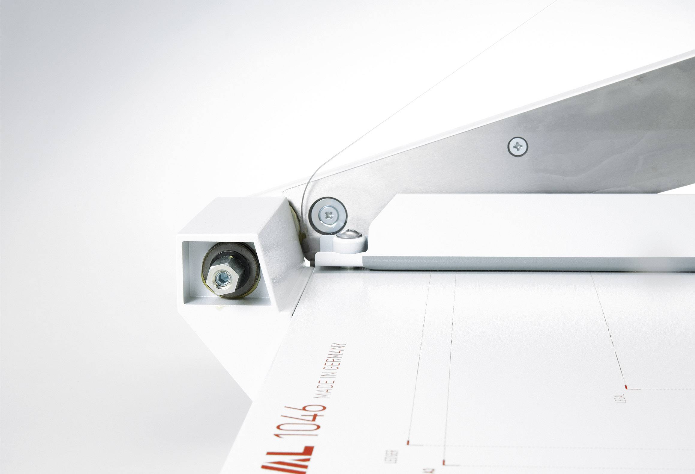 Nahaufnahme einer Papierschneidemaschine mit einem Blatt Papier, das bereit zum Schneiden ist, zeigt präzise Konstruktion und Funktion.