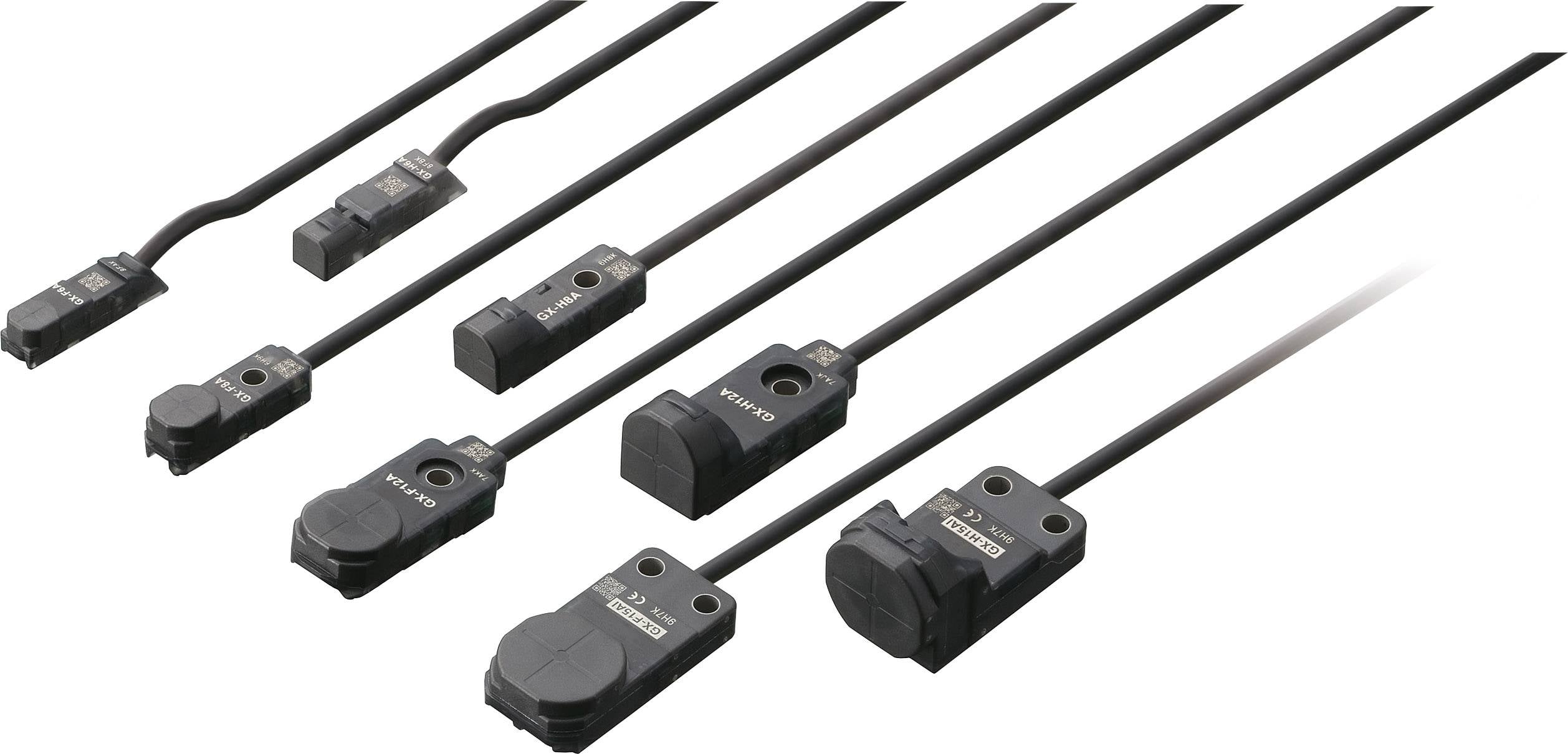 Verschiedene schwarze Näherungssensoren in unterschiedlicher Größe und Form, mit Kabeln für elektrische Verbindungen.