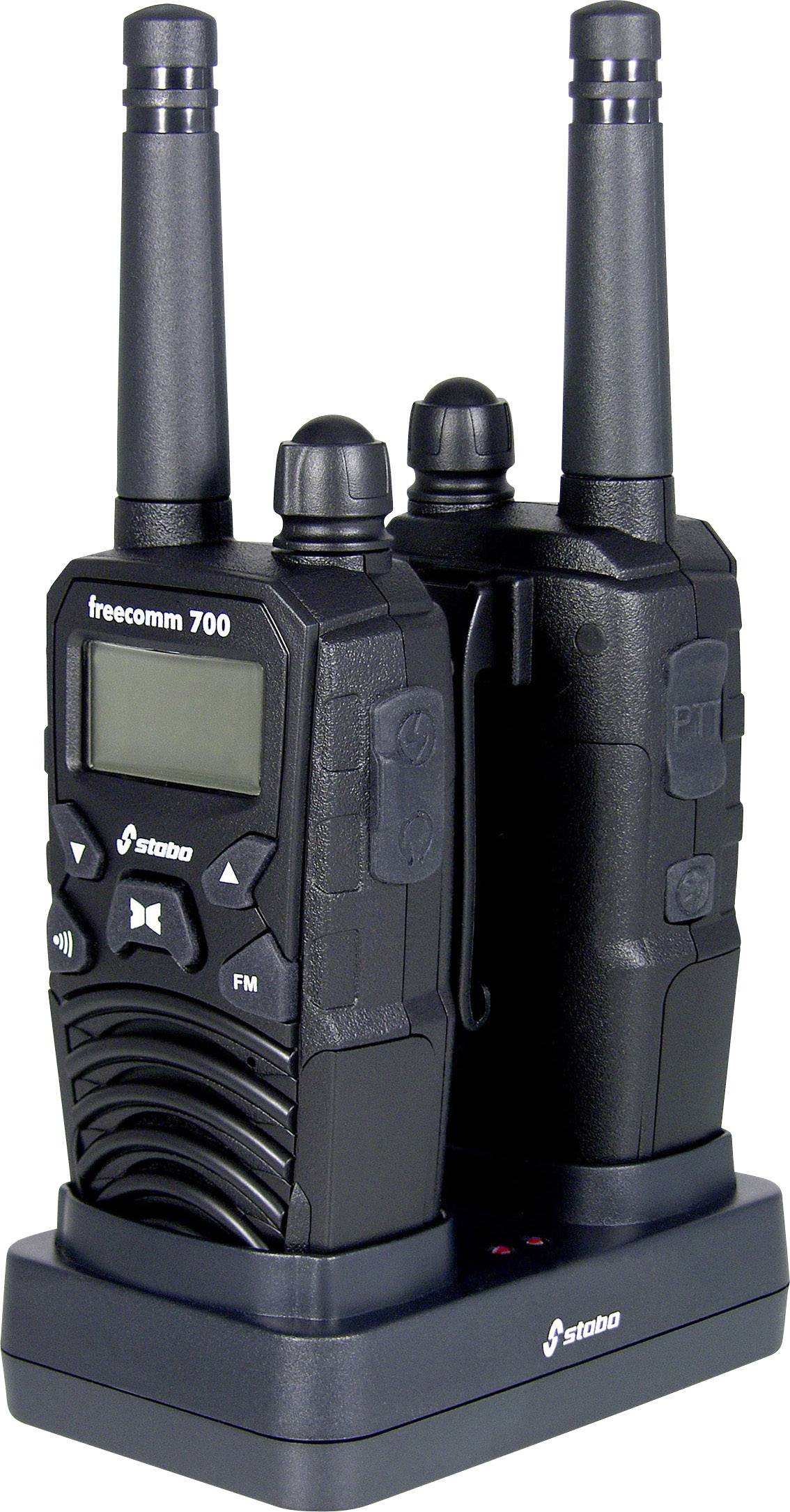 Zwei schwarze Funkgeräte, Modell 'freecomm 700', stehen in einer Ladestation. Eines zeigt ein Display und Tasten zur Bedienung.