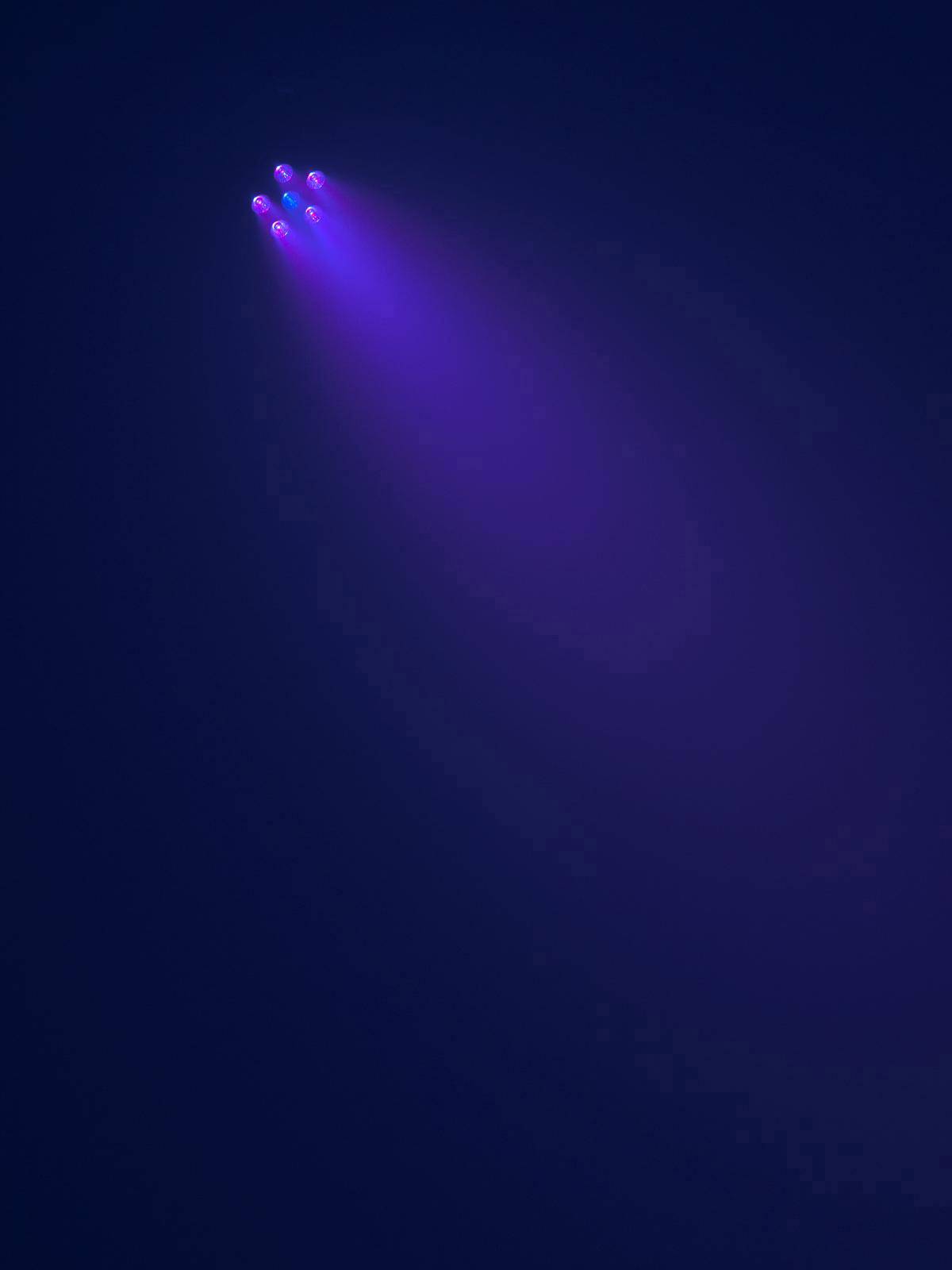 Ein Raketenstart bei Nacht: Mehrere Triebwerke scheinen lila Lichter aus der Rakete im dunklen Himmel auszustrahlen.