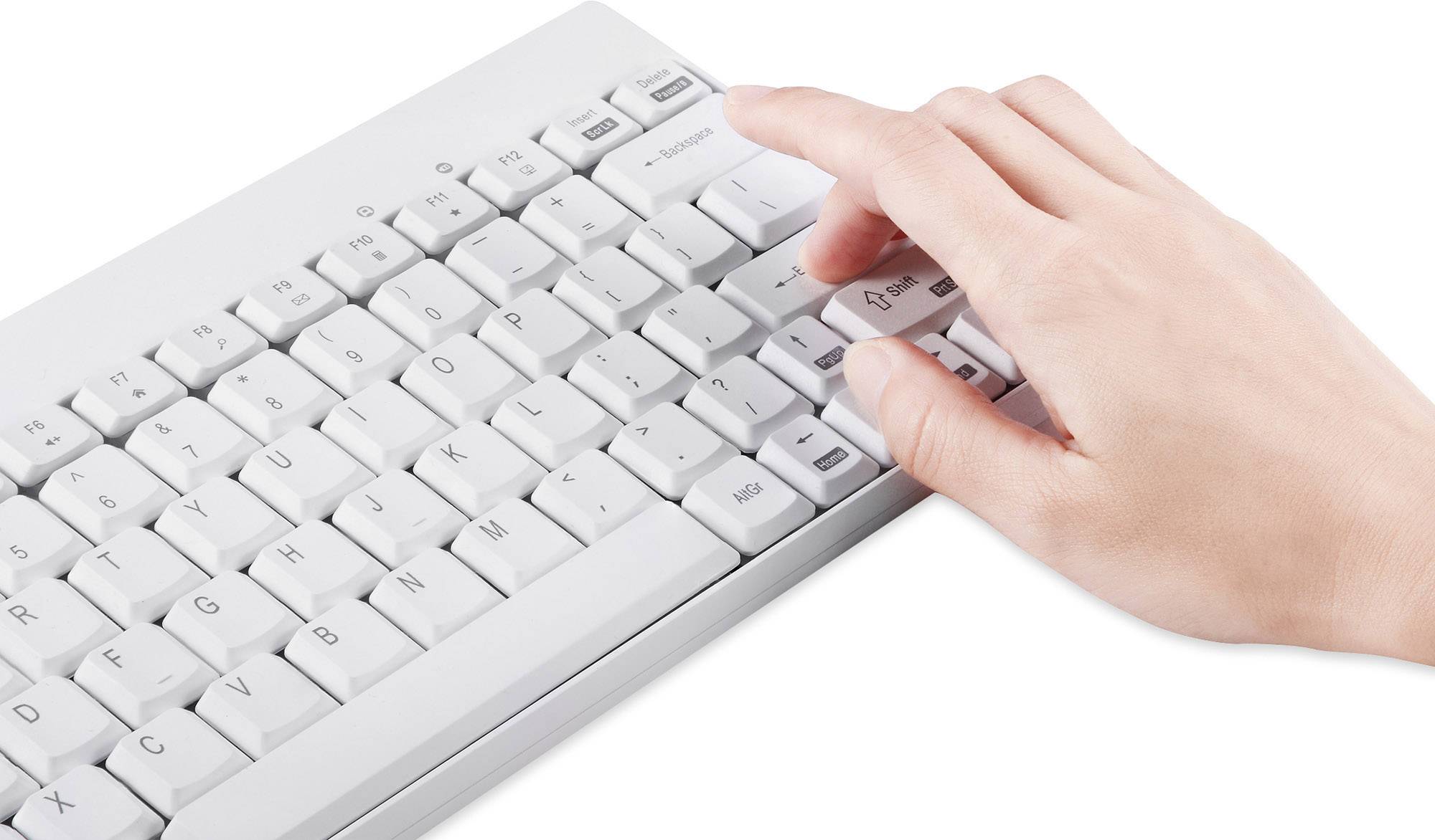 Hand drückt auf eine 'Enter'-Taste auf einer weißen Computertastatur.