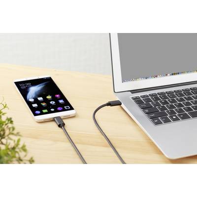 Smartphone verbunden mit einem Laptop über ein USB-Kabel, platziert auf einem Holztisch. Der Laptop-Bildschirm ist ausgeschaltet.