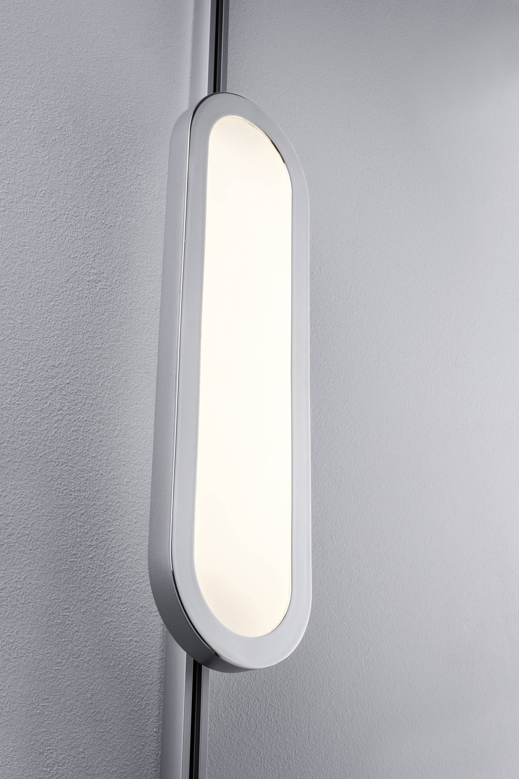 Eine schmale, ovale Wandlampe mit sanftem, gleichmäßigem Lichtschein, montiert an einer hellgrauen Wand.