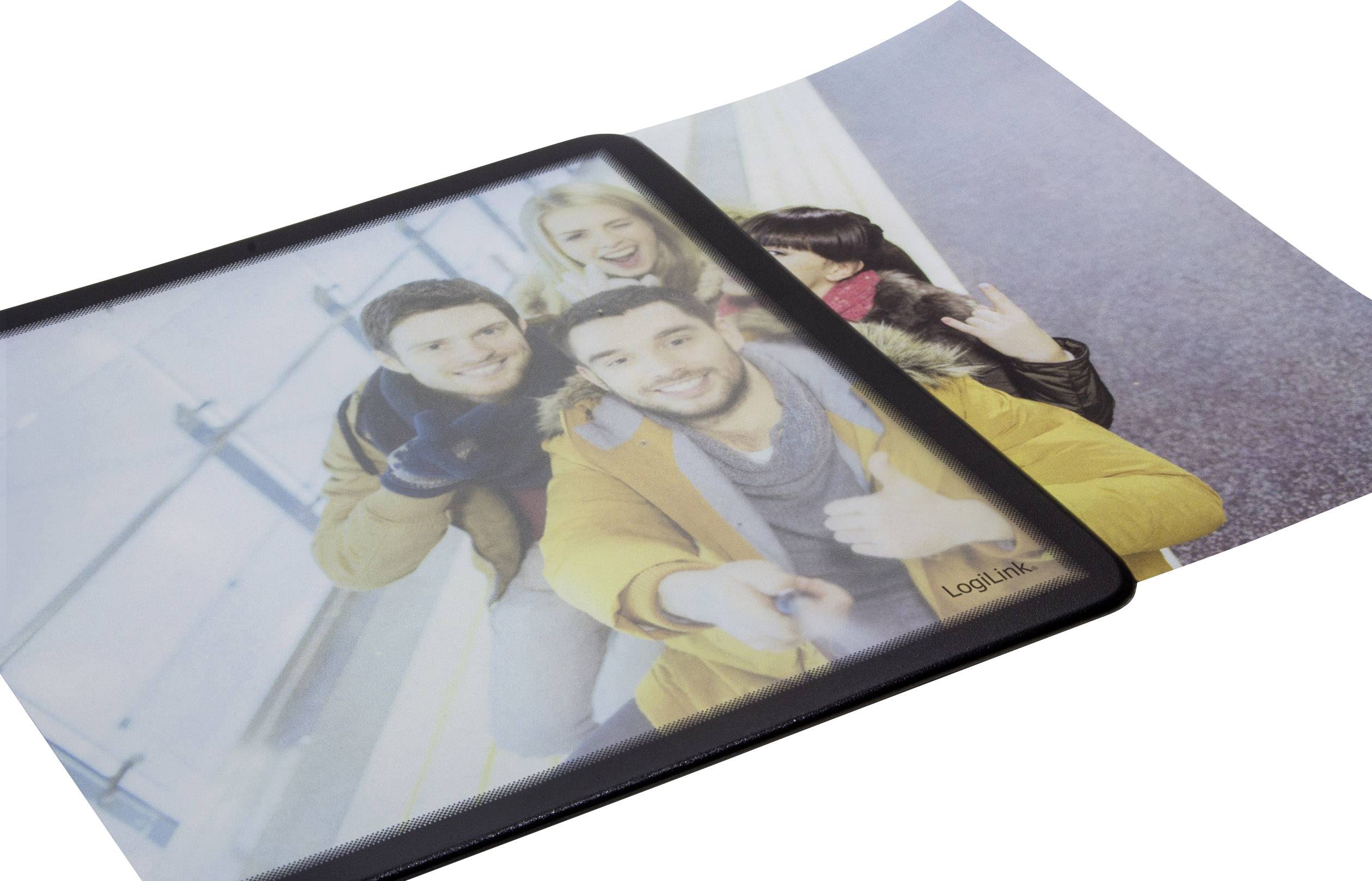 Vier Personen nehmen ein Selfie auf, während sie fröhlich posieren. Das Bild ist auf einem Fotopapier und einer Klarsichthülle platziert.