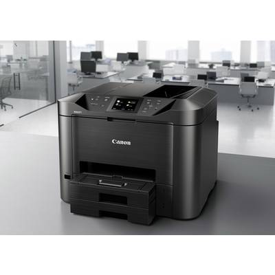 Ein schwarzer Drucker steht in einem modernen Büro. Im Hintergrund sind Schreibtische und Fenster mit Stadtblick zu sehen.