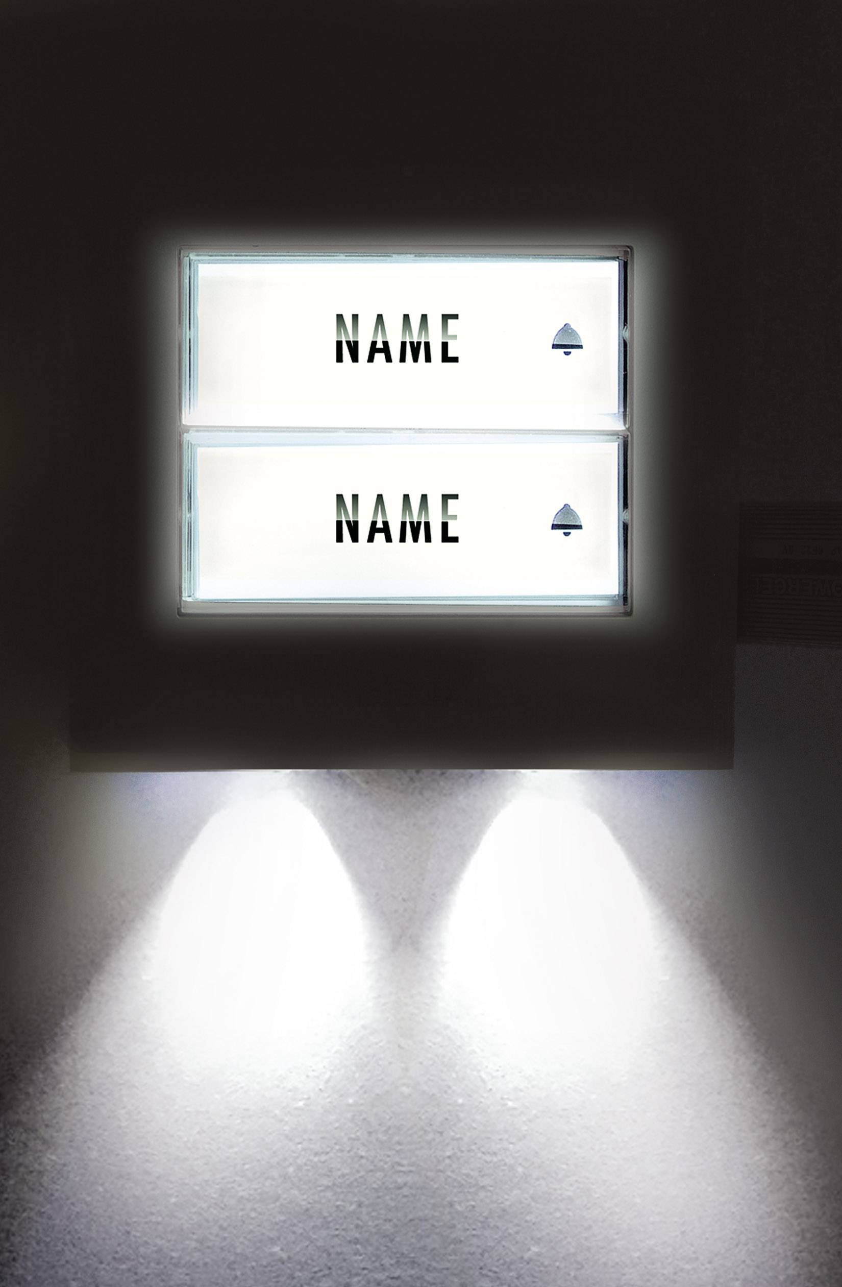 Beleuchtetes Türschild mit zwei nicht lesbaren Namen, getrennt durch eine Linie. Beide Namen daneben von einem kleinen Pfeil begleitet.