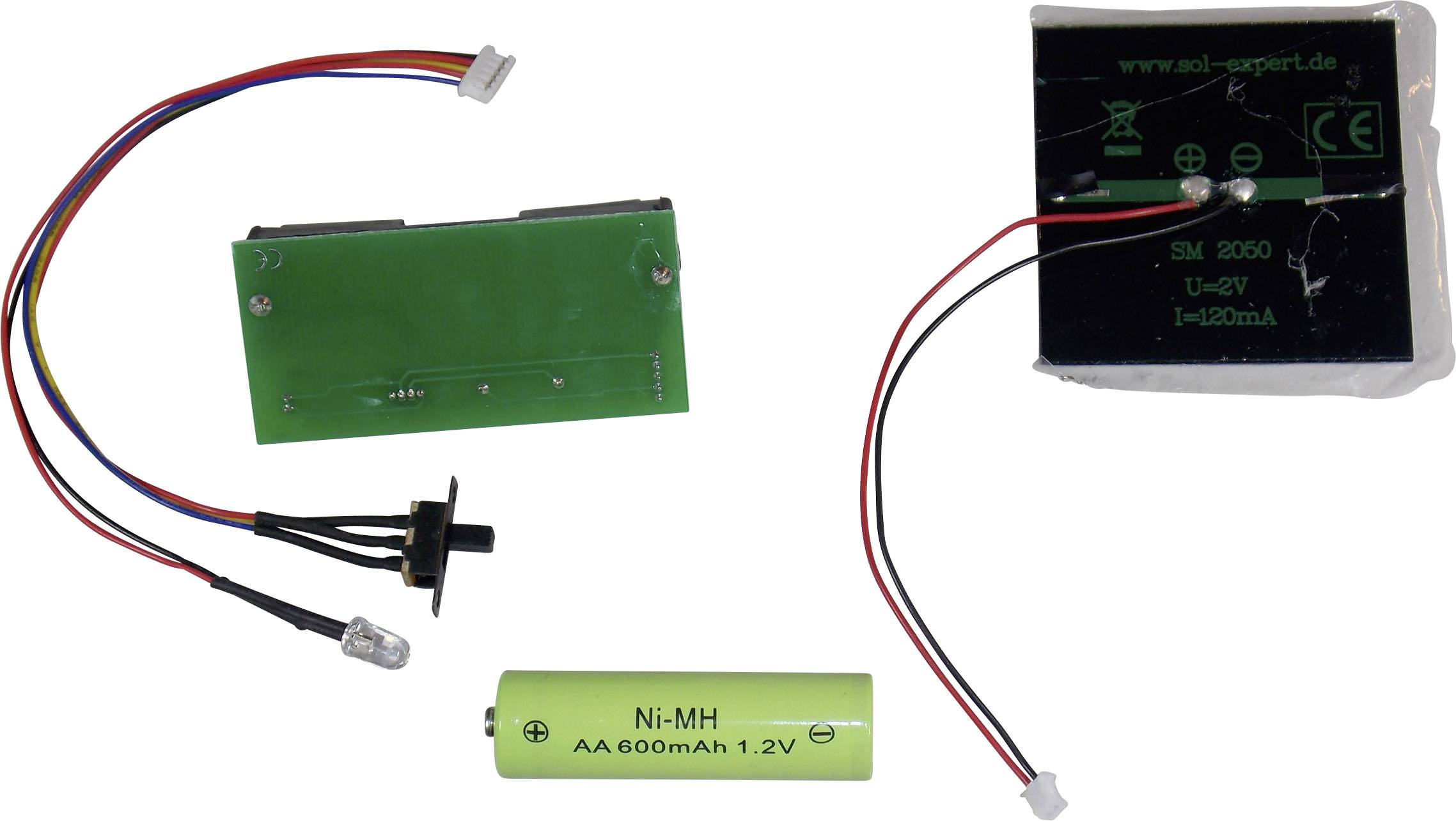 'Elektronische Bauteile: Eine grüne Platine mit Kabeln und Verbindern, ein Akku mit Aufschrift Ni-MH AA 600mAh 1,2V, und ein kleines Solarpanel.'